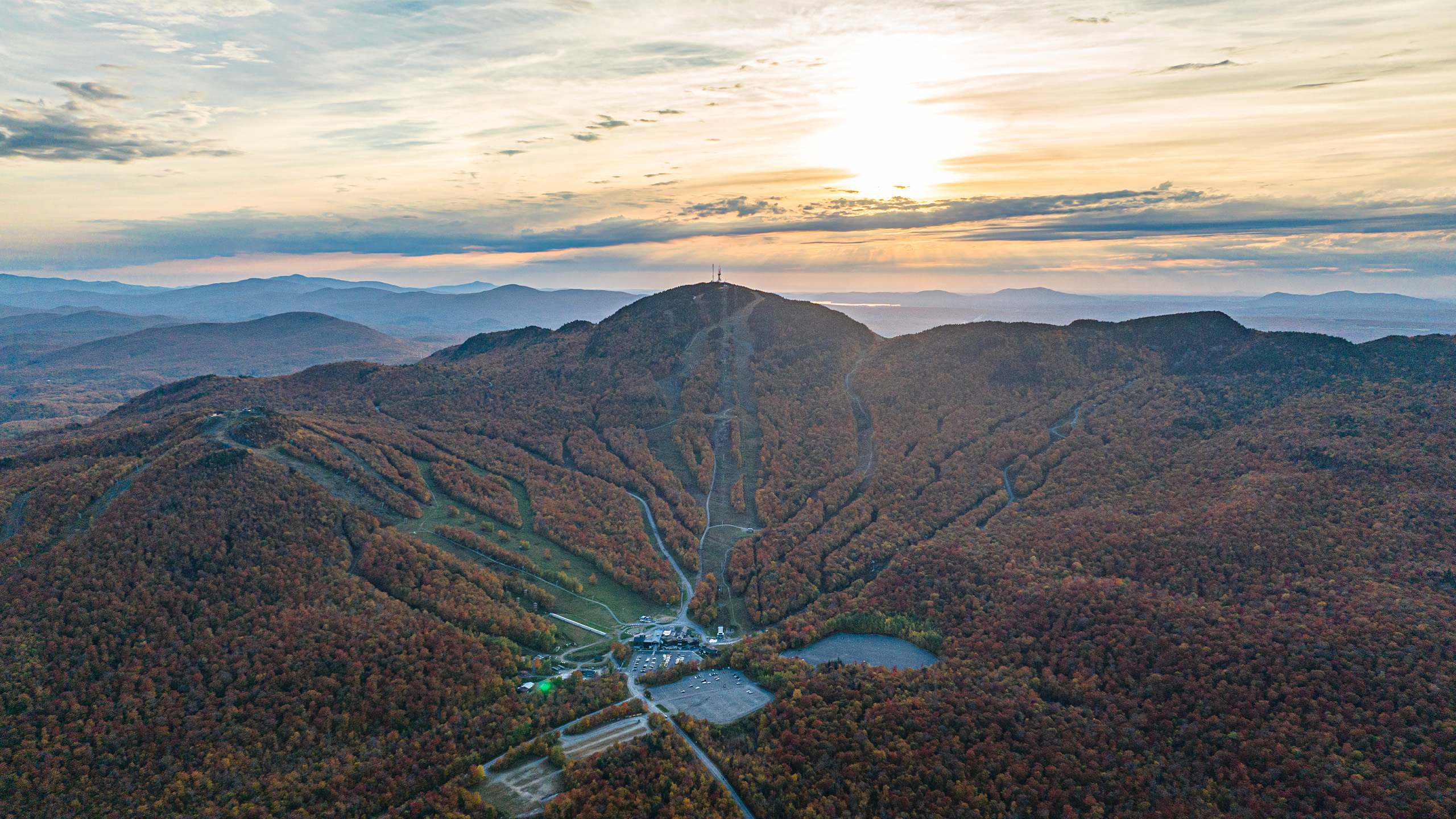 Vue aérienne du Mont-Orford avec ses pistes de ski et un coucher de soleil en Estrie.