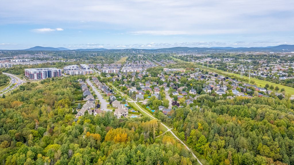 Vue aérienne d’un quartier résidentiel du secteur Les Rivières avec zones boisées